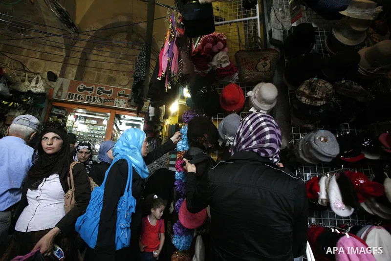 Palestinians shop in the main market during preparations for the Eid al-Adha, in the West Bank city of Jerusalem, on October 22, 2012. Muslims around the world prepare to celebrate Eid Al-Adha, which according to the lun...