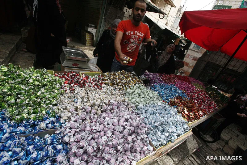 Palestinians shop in the main market during preparations for the Eid al-Adha, in the West Bank city of Jerusalem, on October 22, 2012. Muslims around the world prepare to celebrate Eid Al-Adha, which according to the lun...