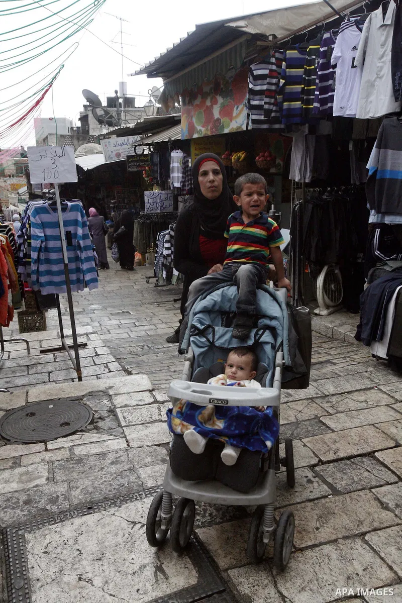 Palestinians shop in the main market during preparations for the Eid al-Adha, in the West Bank city of Jerusalem, on October 22, 2012. Muslims around the world prepare to celebrate Eid Al-Adha, which according to the lun...