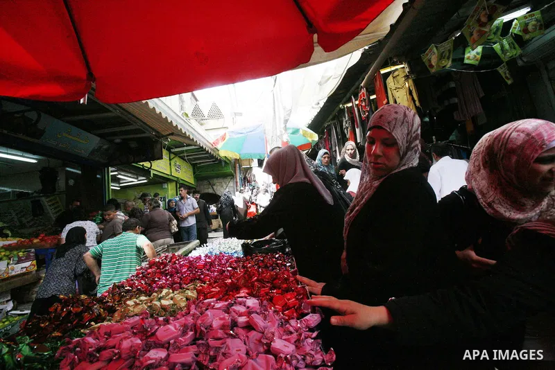 Palestinians shop in the main market during preparations for the Eid al-Adha, in the West Bank city of Jerusalem, on October 22, 2012. Muslims around the world prepare to celebrate Eid Al-Adha, which according to the lun...