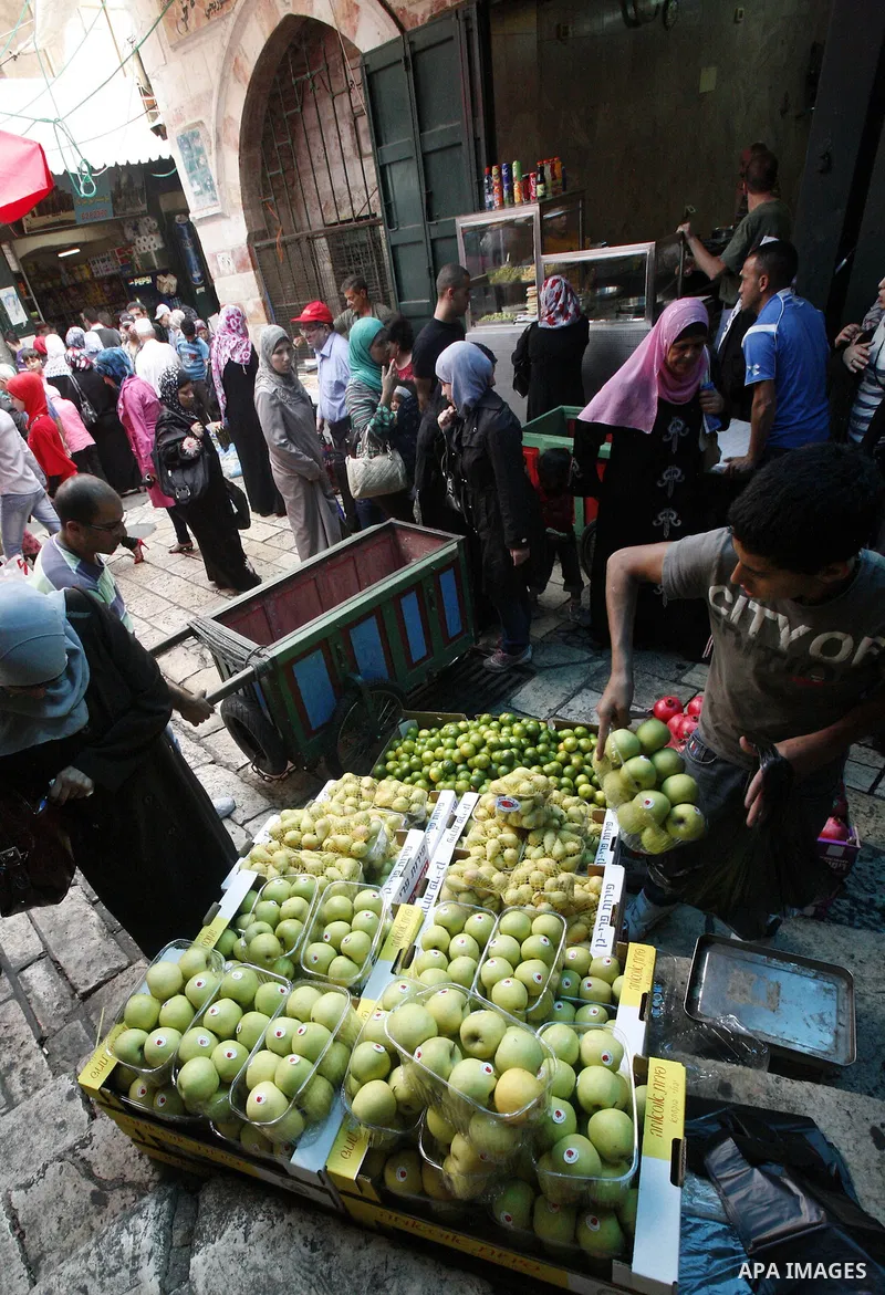 Palestinians shop in the main market during preparations for the Eid al-Adha, in the West Bank city of Jerusalem, on October 22, 2012. Muslims around the world prepare to celebrate Eid Al-Adha, which according to the lun...