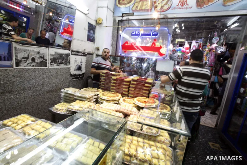 Palestinians shop in the main market during preparations for the Eid al-Adha, in the West Bank city of Jerusalem, on October 22, 2012. Muslims around the world prepare to celebrate Eid Al-Adha, which according to the lun...