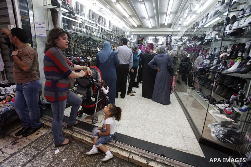 Palestinians shop in the main market during preparations for the Eid al-Adha, in the West Bank city of Jerusalem, on October 22, 2012. Muslims around the world prepare to celebrate Eid Al-Adha, which according to the lun...