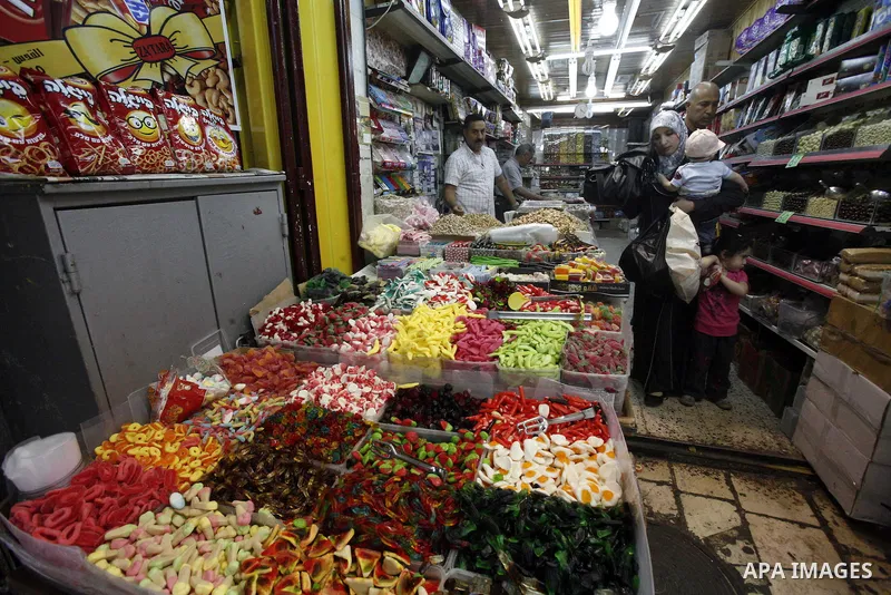Palestinians shop in the main market during preparations for the Eid al-Adha, in the West Bank city of Jerusalem, on October 22, 2012. Muslims around the world prepare to celebrate Eid Al-Adha, which according to the lun...