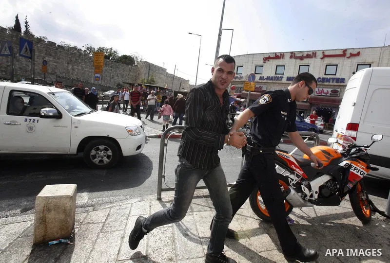 An Israeli police officer detains a Palestinian man at the main market of Jerusalem's old city ahead of Muslim festival of Eid al-Adha on October 22, 2012. Photo by Mahfouz Abu Turk