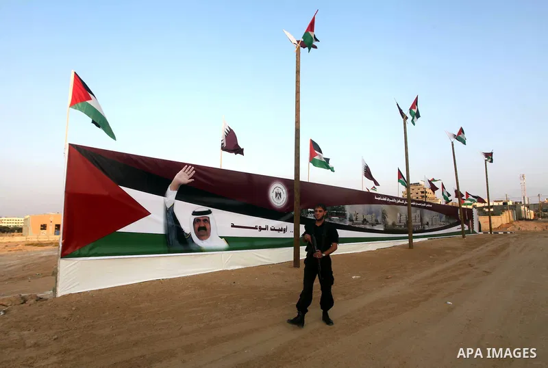 A Palestinian security officer walks near a poster of Qatar's Emir Sheikh Hamad bin Khalifa al-Thani in Gaza city on October 22, 2012. The Qatari emir will visit Gaza on October 23 in the first such visit by an Arab lead...