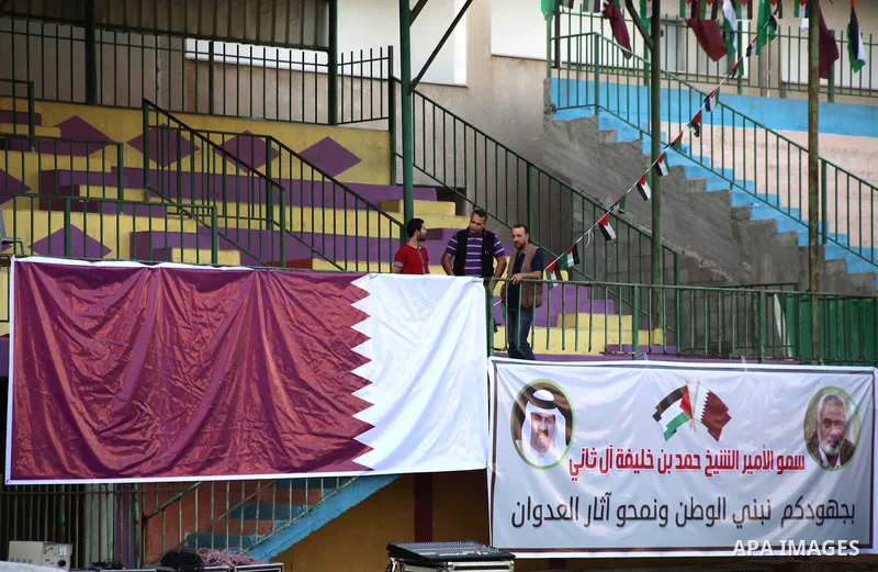 Palestinians attach the Qatari and Palestinian (red, black, white, green) flags in Gaza city on October 22, 2012. The Qatari emir will visit Gaza on October 23 in the first such visit by an Arab leader since Hamas took o...