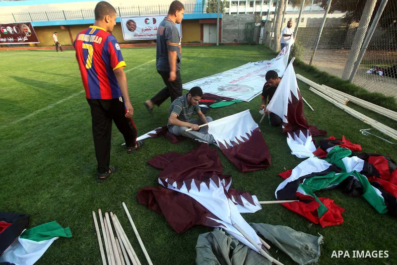 Palestinians attach the Qatari and Palestinian (red, black, white, green) flags in Gaza city on October 22, 2012. The Qatari emir will visit Gaza on October 23 in the first such visit by an Arab leader since Hamas took o...