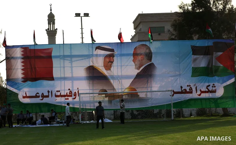 Palestinians attach posters of Hamas prime minister Ismail Haniya and Qatar's Emir Sheikh Hamad bin Khalifa al-Thani in Gaza city on October 22, 2012. The Qatari emir will visit Gaza on October 23 in the first such visit...
