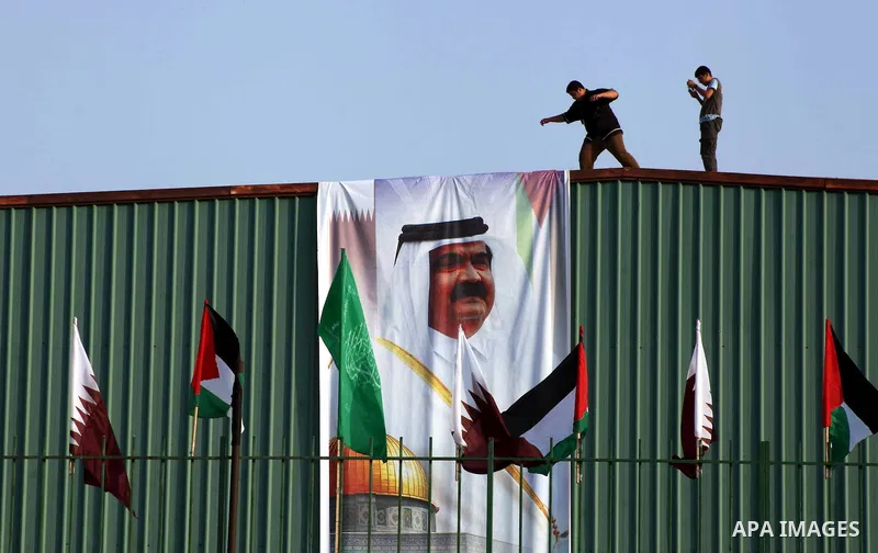 Palestinians attach poster of Qatar's Emir Sheikh Hamad bin Khalifa al-Thani in Gaza city on October 22, 2012. The Qatari emir will visit Gaza on October 23 in the first such visit by an Arab leader since Hamas took over...