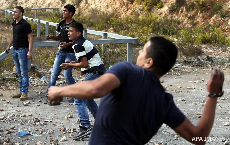 Palestinian protesters throw stones towards Israeli security forces outside Israel's Ofer military prison, near the West Bank city of Ramallah, on October 22, 2012, following a demonstration in support of Palestinian pri...