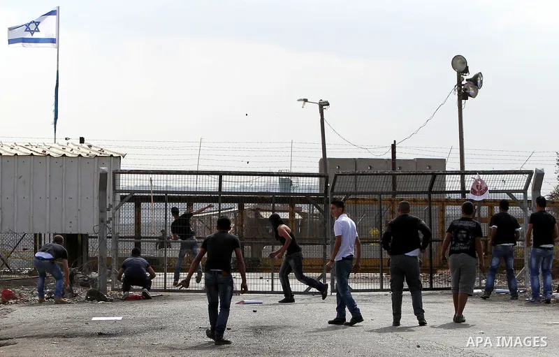 Palestinian protesters throw stones towards Israeli security forces outside Israel's Ofer military prison, near the West Bank city of Ramallah, on October 22, 2012, following a demonstration in support of Palestinian pri...