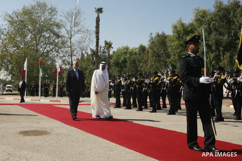 Qatari Emir Sheikh Hamad bin Khalifa al-Thani and Palestinian Prime Minister in Gaza Strip, Ismail Haniyah receive greeting from the honor guards at Rafah border crossing with Egypt on October 23, 2012. Sheikh Hamad bin...