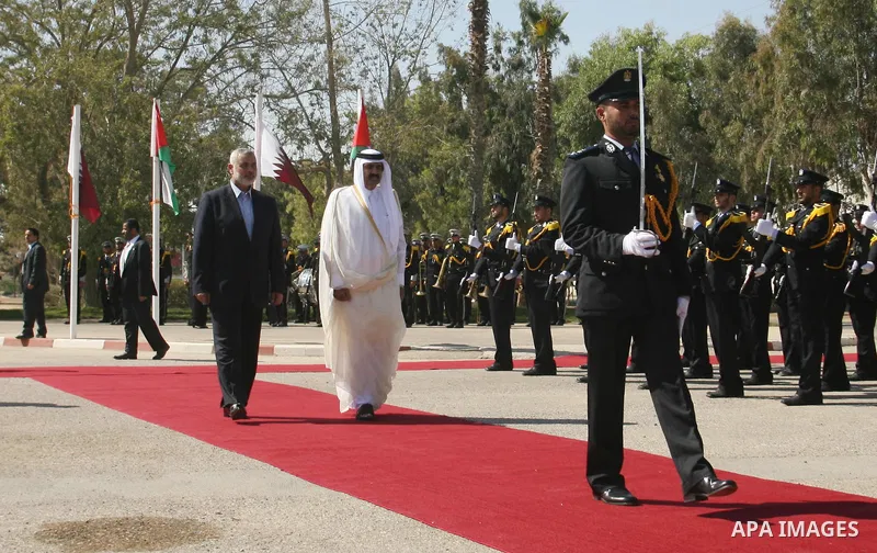 Qatari Emir Sheikh Hamad bin Khalifa al-Thani and Palestinian Prime Minister in Gaza Strip, Ismail Haniyah receive greeting from the honor guards at Rafah border crossing with Egypt on October 23, 2012. Sheikh Hamad bin...
