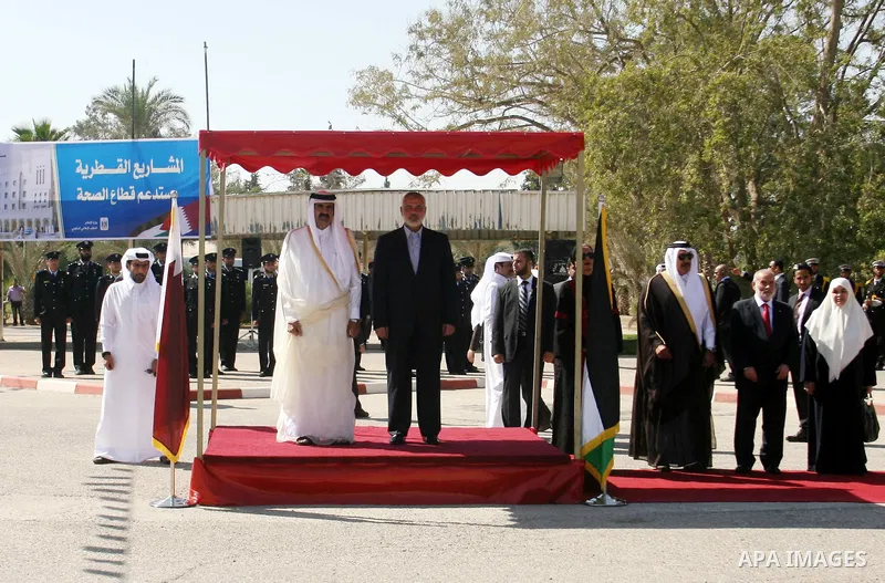 Qatari Emir Sheikh Hamad bin Khalifa al-Thani and Palestinian Prime Minister in Gaza Strip, Ismail Haniyah receive greeting from the honor guards at Rafah border crossing with Egypt on October 23, 2012. Sheikh Hamad bin...