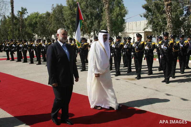 Qatari Emir Sheikh Hamad bin Khalifa al-Thani and Palestinian Prime Minister in Gaza Strip, Ismail Haniyah receive greeting from the honor guards at Rafah border crossing with Egypt on October 23, 2012. Sheikh Hamad bin...