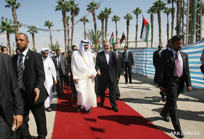 Palestinian Prime Minister in Gaza strip, Ismail Haniyeh walks with the Emir of Qatar Sheik Hamad bin Khalifa al-Thani during a welcoming ceremony at the Rafah border crossing with Egypt in the southern Gaza Strip Octobe...