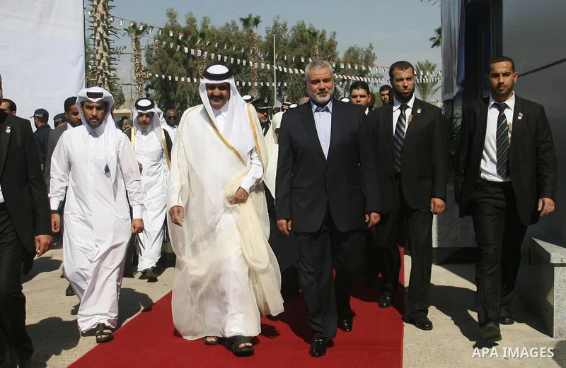 Palestinian Prime Minister in Gaza strip, Ismail Haniyeh walks with the Emir of Qatar Sheik Hamad bin Khalifa al-Thani during a welcoming ceremony at the Rafah border crossing with Egypt in the southern Gaza Strip Octobe...