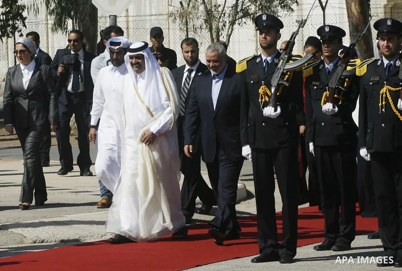 Palestinian Prime Minister in Gaza strip, Ismail Haniyeh walks with the Emir of Qatar Sheik Hamad bin Khalifa al-Thani during a welcoming ceremony at the Rafah border crossing with Egypt in the southern Gaza Strip Octobe...