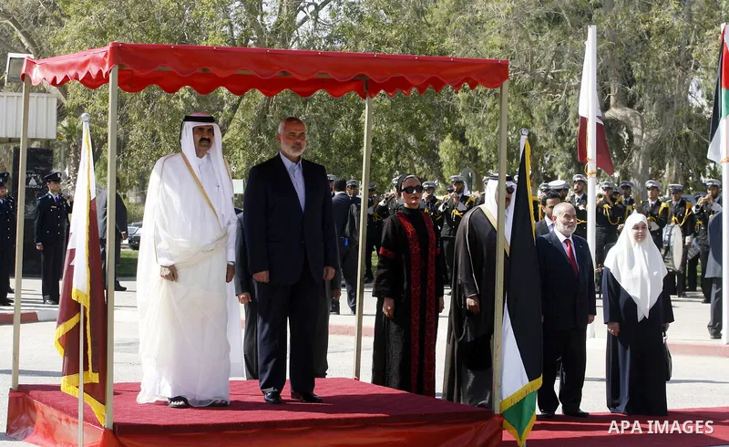 Palestinian Prime Minister in Gaza strip, Ismail Haniyeh walks with the Emir of Qatar Sheik Hamad bin Khalifa al-Thani during a welcoming ceremony at the Rafah border crossing with Egypt in the southern Gaza Strip Octobe...