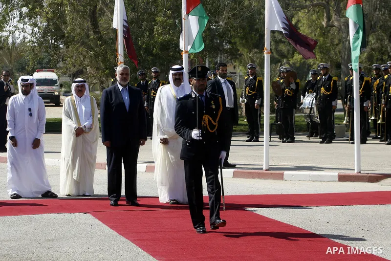 Palestinian Prime Minister in Gaza strip, Ismail Haniyeh walks with the Emir of Qatar Sheik Hamad bin Khalifa al-Thani during a welcoming ceremony at the Rafah border crossing with Egypt in the southern Gaza Strip Octobe...