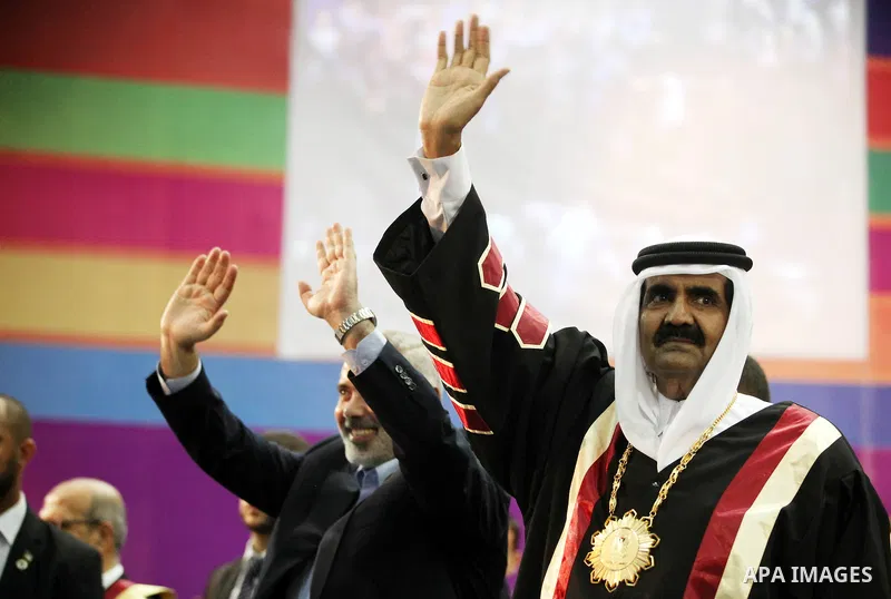 Qatari Emir Sheikh Hamad bin Khalifa al-Thani and Palestinian prime minister in Gaza strip, Ismail Haniyah wave to the crowds at the Islamic University in Gaza city on October 23, 2012. The Emir of Qatar entered the Gaza...