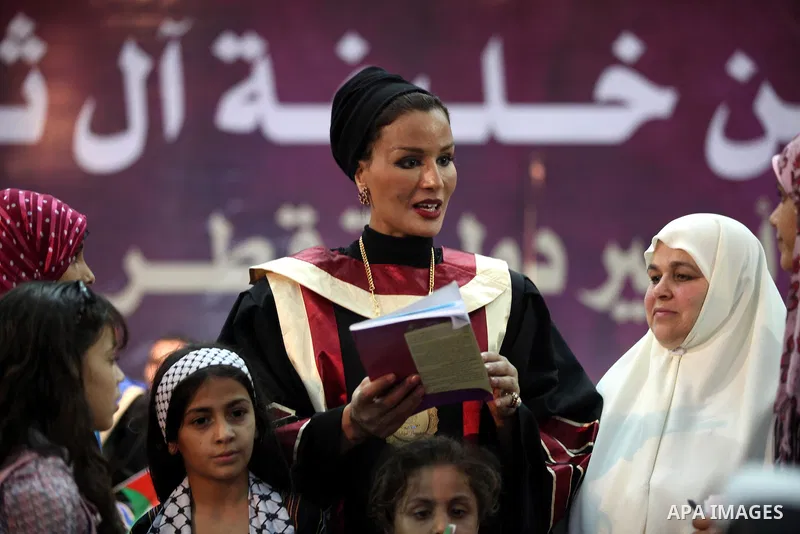 Qatar's First Lady Sheikha Mozah bint Nasser al-Missned stands with the wife of Gaza's prime minister Ismail Haniyah surrounding with Palestinian children at the Islamic University in Gaza city on October 23, 2012. The E...