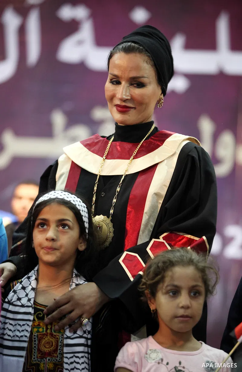 Qatar's First Lady Sheikha Mozah bint Nasser al-Missned stands with the wife of Gaza's prime minister Ismail Haniyah surrounding with Palestinian children at the Islamic University in Gaza city on October 23, 2012. The E...
