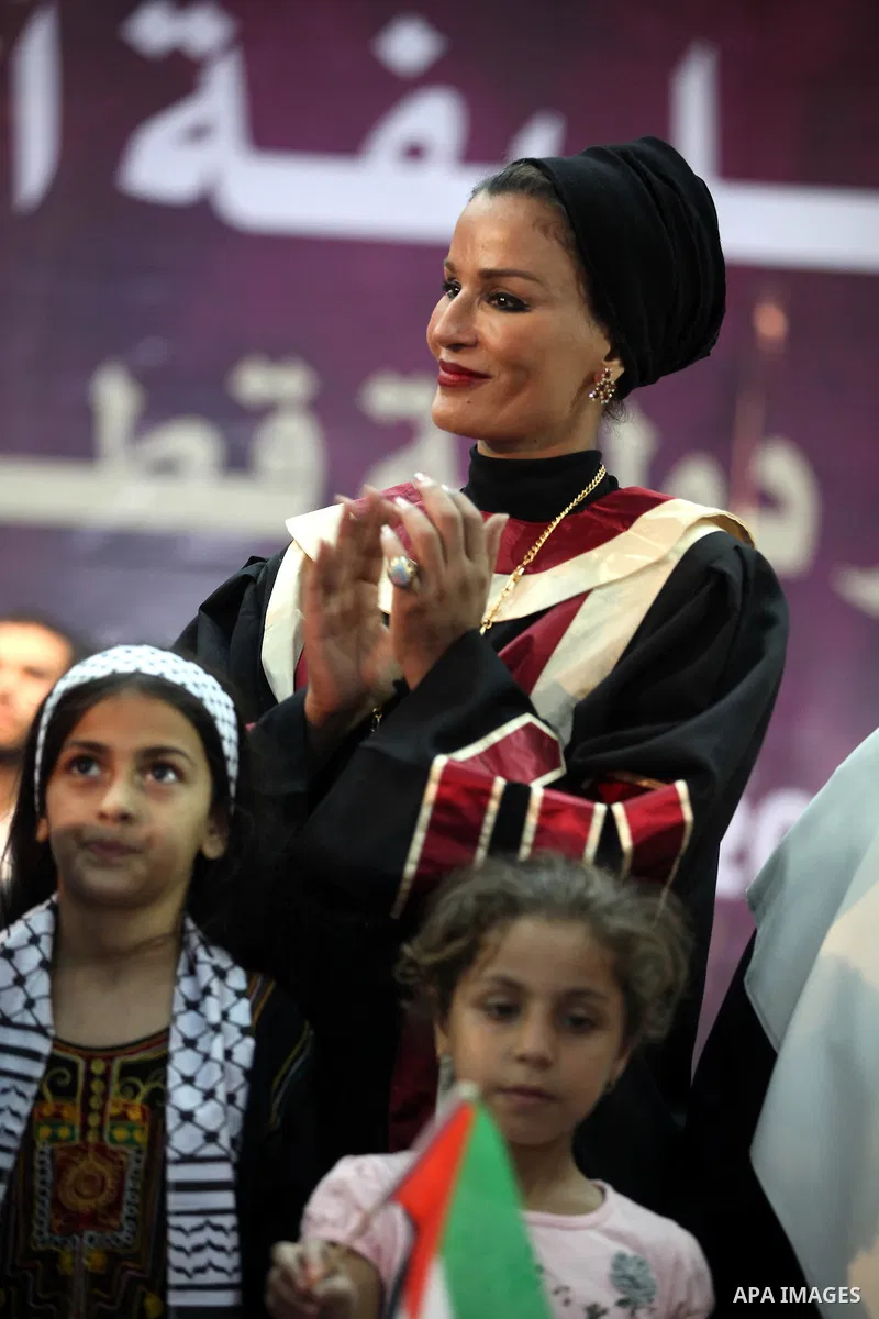 Qatar's First Lady Sheikha Mozah bint Nasser al-Missned stands with the wife of Gaza's prime minister Ismail Haniyah surrounding with Palestinian children at the Islamic University in Gaza city on October 23, 2012. The E...