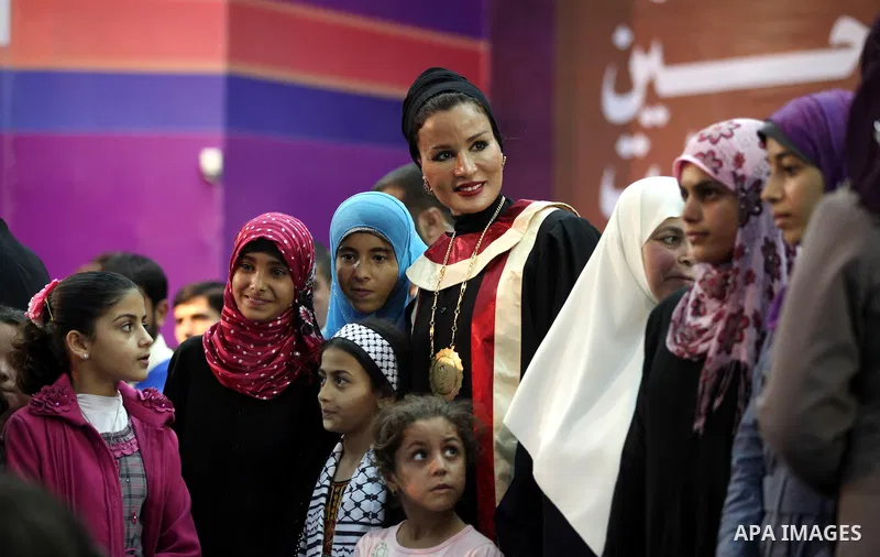 Qatar's First Lady Sheikha Mozah bint Nasser al-Missned stands with the wife of Gaza's prime minister Ismail Haniyah surrounding with Palestinian children at the Islamic University in Gaza city on October 23, 2012. The E...