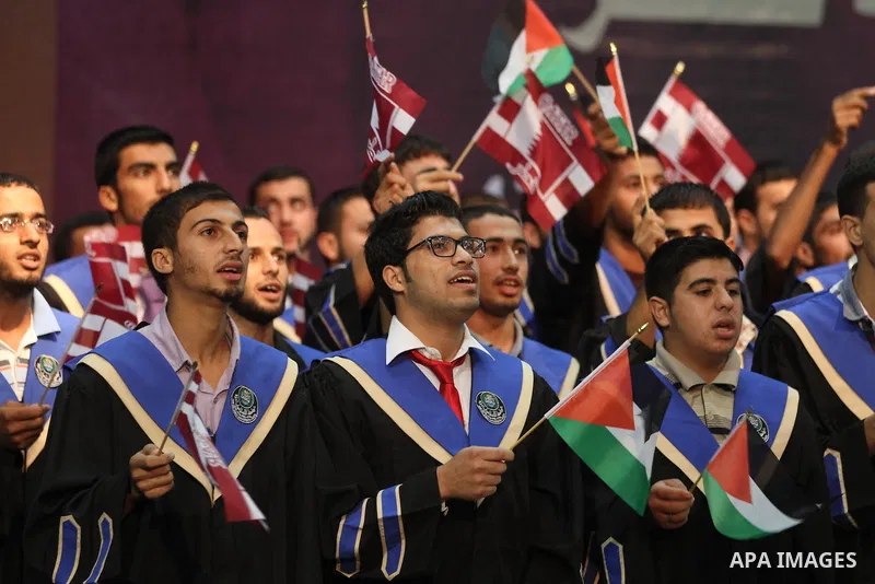 Palestinians gather during the arrival of Emir of Qatar Sheik Hamad bin Khalifa al-Thani at the Islamic University in Gaza city on October 23, 2012. The Emir of Qatar entered the Gaza Strip on Tuesday for a visit that br...
