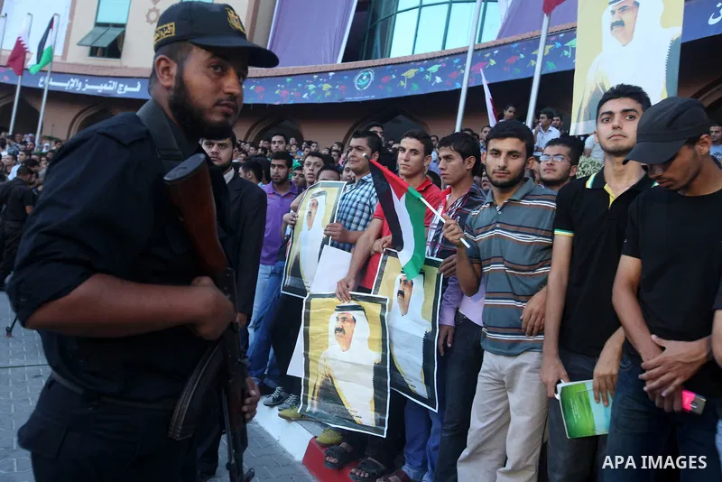 Palestinians gather during the arrival of Emir of Qatar Sheik Hamad bin Khalifa al-Thani at the Islamic University in Gaza city on October 23, 2012. The Emir of Qatar entered the Gaza Strip on Tuesday for a visit that br...