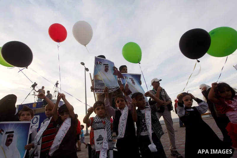 Palestinians hold balloons in the colour of the national flag waits for the arrival of Emir of Qatar Sheik Hamad bin Khalifa al-Thani in Gaza City on October 23, 2012. Qatar's emir was warmly welcomed on a landmark tour...