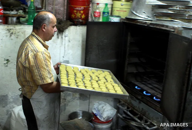A Palestinian worker makes traditional date-filled cookies in preparation for the of Eid al-Adha, in the West Bank city of Nablus, on October 23, 2012. Muslims around the world prepare to celebrate Eid Al-Adha, which acc...