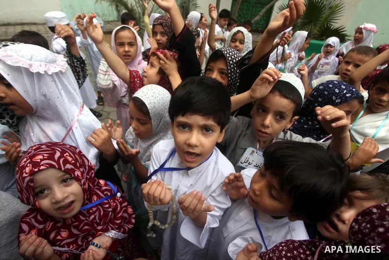 Palestinian children gather around a makeshift cube representing the holy Kaaba in Gaza City, on October 24, 2012, as part of training children how to perform Hajj pilgrimage. Muslims from around the world flood Saudi ci...