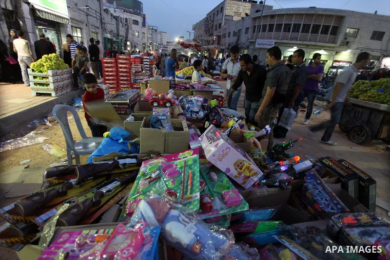Palestinians shop at a market during preparations for the Eid al-Adha, in the West Bank city of Ramallah, on October 24, 2012. Muslims around the world prepare to celebrate Eid Al-Adha, which according to the lunar calen...