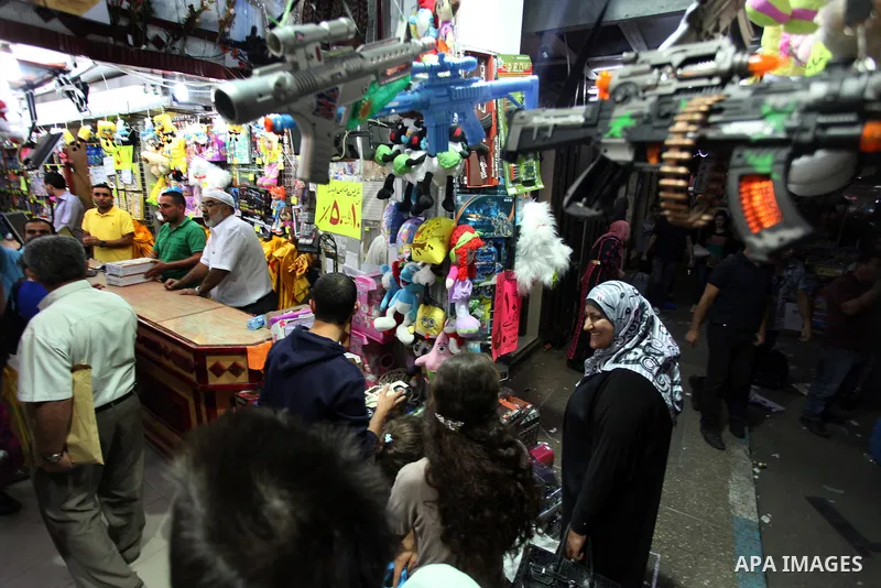 Palestinians shop at a market during preparations for the Eid al-Adha, in the West Bank city of Ramallah, on October 24, 2012. Muslims around the world prepare to celebrate Eid Al-Adha, which according to the lunar calen...