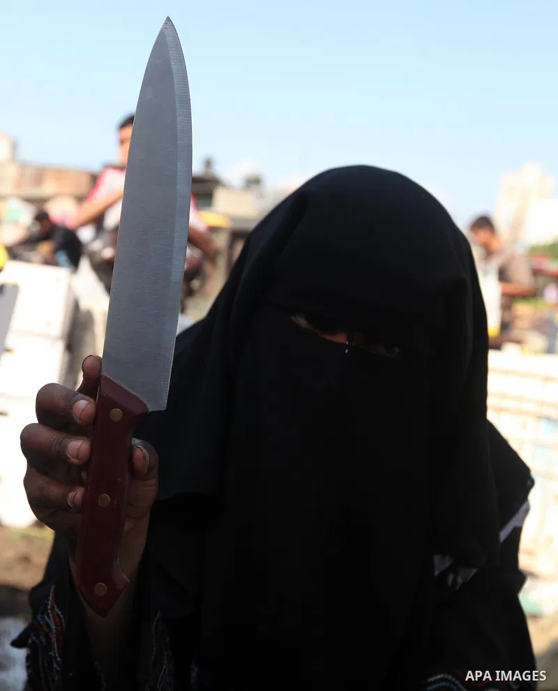 A Palestinian woman buys knifes in Gaza city, on October 25, 2012, in preparation for Eid al-Adha. Millions of Muslims around the world celebrate Eid al-Adha or "Feast of the Sacrifice", which marks the end of the annual...