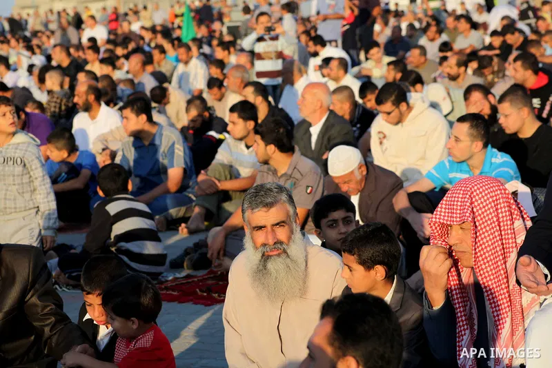 Palestinians listen to a speech by Palestinian Prime Minister in gaza, Ismail Haniya during a mass prayer on the first day of the Muslim holiday of Eid al-Adha, at al-Nusairat, in the central Gaza Strip, on October 26, 2...