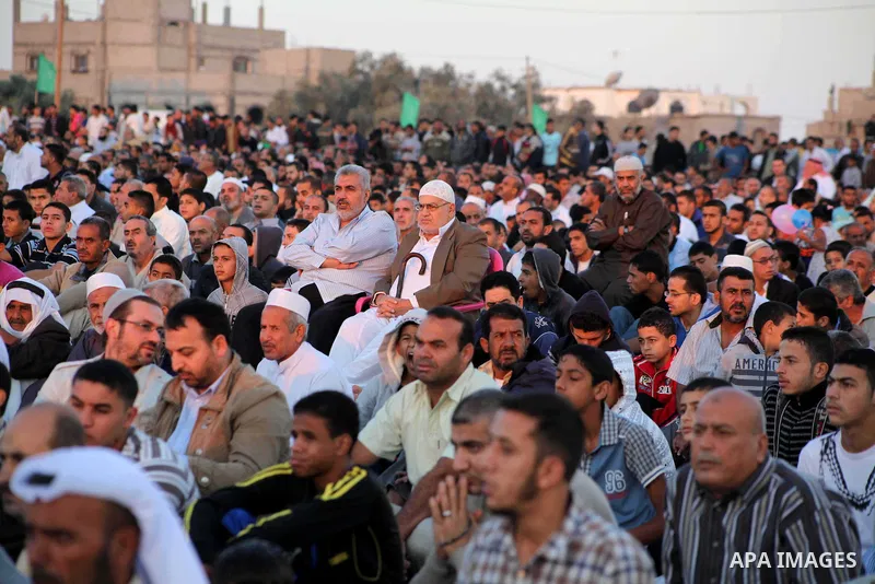 Palestinians listen to a speech by Palestinian Prime Minister in gaza, Ismail Haniya during a mass prayer on the first day of the Muslim holiday of Eid al-Adha, at al-Nusairat, in the central Gaza Strip, on October 26, 2...