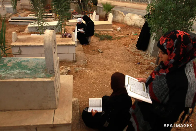 Palestinians visit the graves of relatives at a cemetery in the West Bank city of Nablus on the first day of Eid al-Adha, on October 26, 2012 as Muslims worldwide commemorate Eid al-Adha, or the Feast of the Sacrifice, m...
