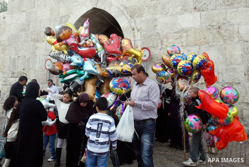 Palestinian children hold balloons in front of the Dome of the Rock in Jerusalem's Old city, on the first day of Eid al-Adha October 26, 2012. Muslims around the world celebrate Eid al-Adha to mark the end of the Haj by...