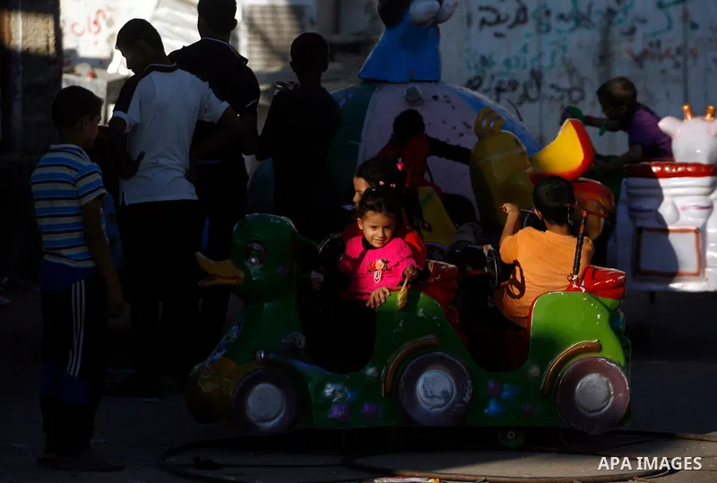 Palestinian children enjoy a ride during the third day of Eid al-Adha in Rafah refugee camp in the southern Gaza Strip on, 28 October 2012. Eid al-Adha, or the Feast of the Sacrifice, is celebrated to commemorate the Pro...