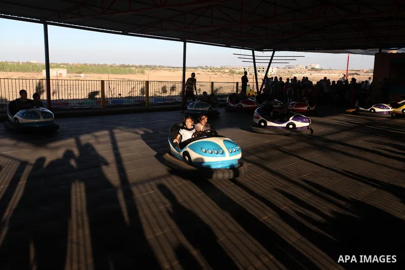 Palestinians enjoy themselves at an amusement park in Gaza City as the Muslim world celebrates the third day of the Eid al-Adha holiday on October 28, 2012. Eid al-Adha or "Feast of the Sacrifice" marks the end of the an...