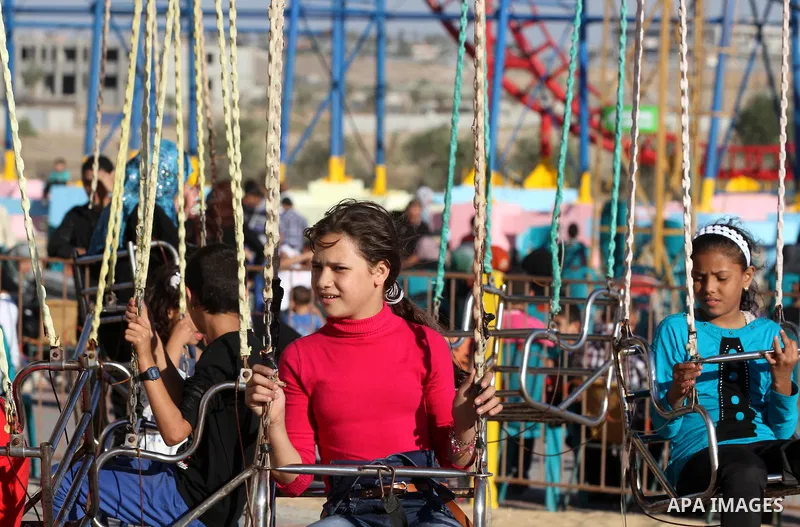 Palestinians enjoy themselves at an amusement park in Gaza City as the Muslim world celebrates the third day of the Eid al-Adha holiday on October 28, 2012. Eid al-Adha or "Feast of the Sacrifice" marks the end of the an...
