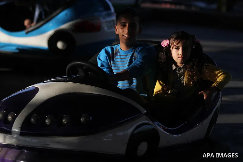 Palestinians enjoy themselves at an amusement park in Gaza City as the Muslim world celebrates the third day of the Eid al-Adha holiday on October 28, 2012. Eid al-Adha or "Feast of the Sacrifice" marks the end of the an...