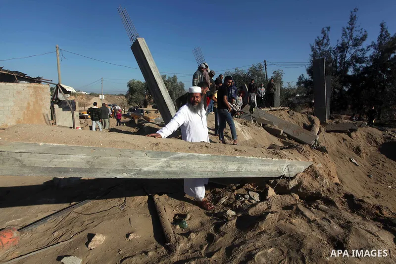 Palestinians inspect the damage to a building following an Israeli attack in al-Bureij, in the center of the Gaza Strip on October 29, 2012. Gaza militants fired 11 rockets over the border overnight in response to two la...