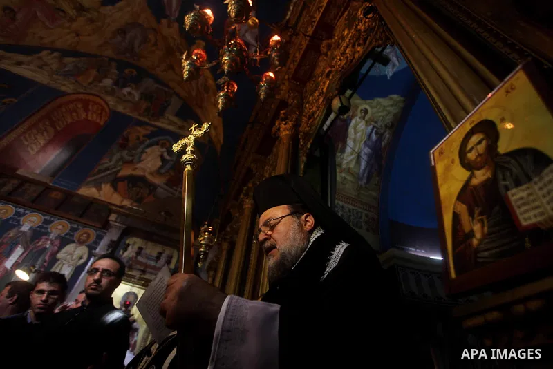 A Palestinian priest prays on Christian Hossam Al-Tawil during his funeral at the Church of Saint Porphyrius in Gaza city on Nov. 01, 2012. Al-Tawil passed away in Egypt after seeking medical treatment in the country. He...