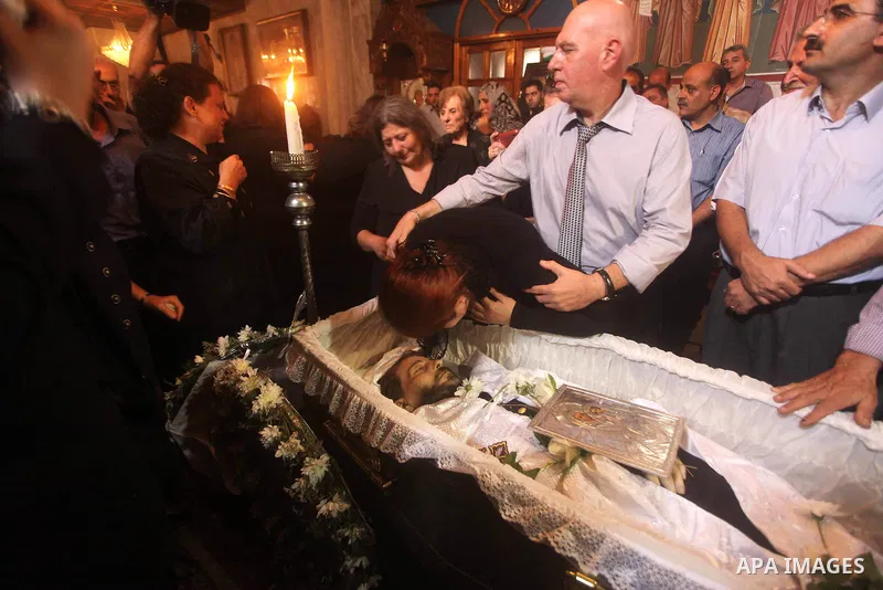 Palestinian relatives of Christian Hossam Al-Tawil mourn on his body during his funeral at the Church of Saint Porphyrius in Gaza city on Nov. 01, 2012. Al-Tawil passed away in Egypt after seeking medical treatment in th...