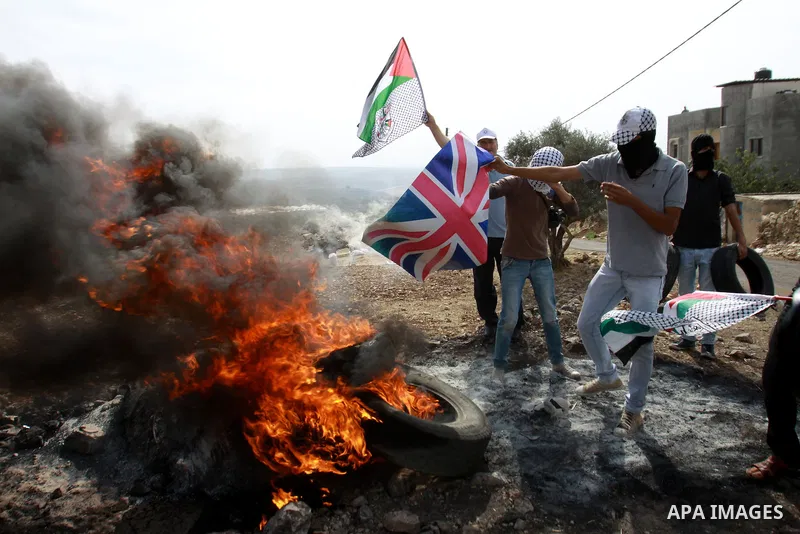 Palestinian protesters burn the United Kingdom's flag during a demonstration marking the anniversary of Balfour Declaration, in the village of Kfar Qaddum, near the West Bank city of Nablus on November 02, 2012. The Balf...